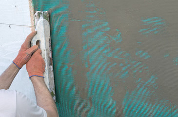  applying putty to the  wall using a spatula