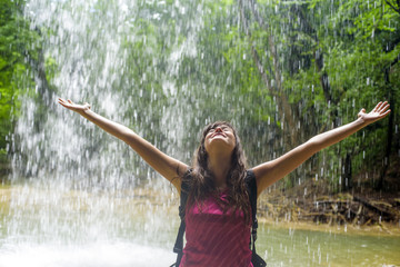 cheering caucasian female hiker near the waterfall