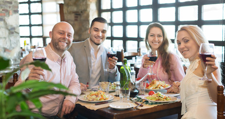 Fototapeta na wymiar Young people enjoying food at tavern