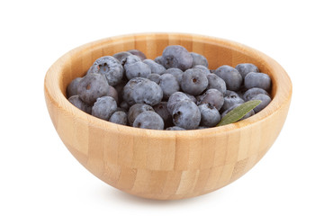 Wooden bowl with blueberry berries on a white background