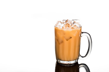 Refreshing ice cold tea with milk in transparent glass isolated in white