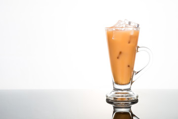 Refreshing ice cold tea with milk in transparent glass