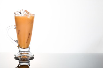Refreshing ice cold tea with milk in transparent glass
