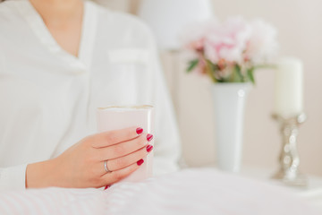 Hands holding a pink coffee cup