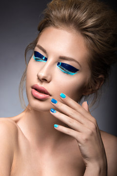 Beautiful girl with bright creative fashion makeup and blue nail