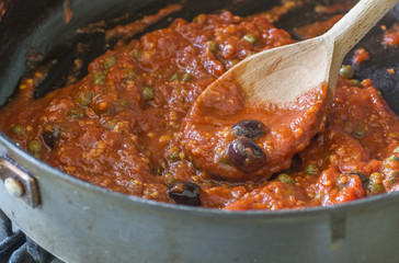  Freshly cooked tomato sauce for pasta with olives, capers and anchovies a la Puttanesca