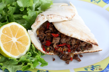 healthy eating: grilled beef taco with vegetables, salad and lemon served on plate
