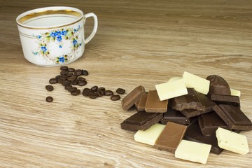 We love coffee and chocolate. Chocolate and coffee on a wooden table. Sweet treat with coffee.
