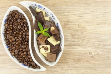 We love coffee and chocolate. Chocolate and coffee on a wooden table. Sweet treat with coffee.
