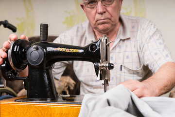 Senior Man Using Old Fashioned Sewing Machine