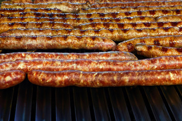Grilled and raw sausages over barbecue lines