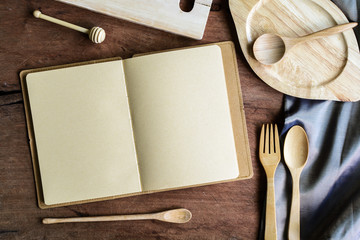 Notebook amd wooden utensil in kitchen on old wooden background