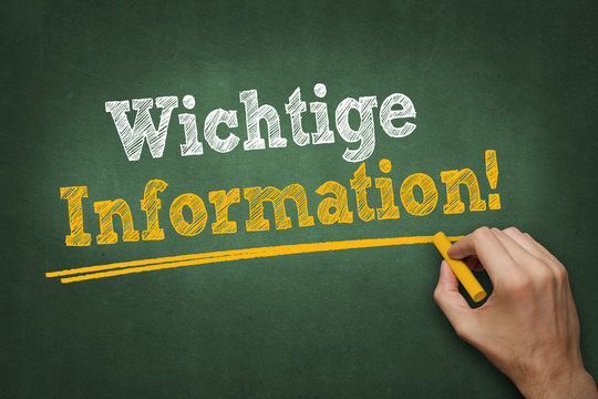 Hand schreibt Text "Wichtige Information!" auf Kreidetafel