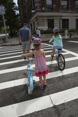 Young children on bicycles crossing the street A rear view