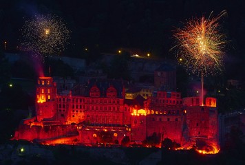 Fototapeta na wymiar Das Heidelberger Schloß rot beleuchtet mit Raketen Feuerwerk