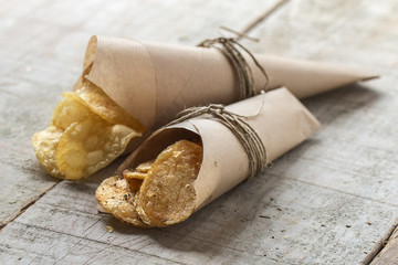 Potato chips with herbs with wooden background