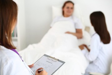 Obraz premium Female medicine doctor filling in patient medical history list