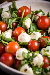 Italian style tomato and mozzarella salad in rustic bowl