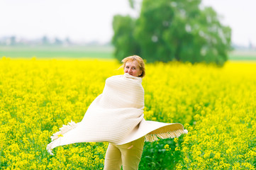 The beautiful woman dances on a rape field