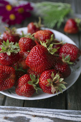 strawberries on white plates, on old gray wood table