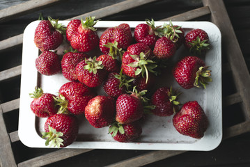 Strawberries in the tray on a wooden background. Top view