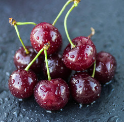 Ripe juicy cherries with water drops on dark background