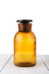 Vintage medicine bottle on wooden table isolated on white
