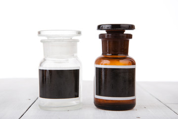 Vintage medicine bottles with blank labels on wooden table
