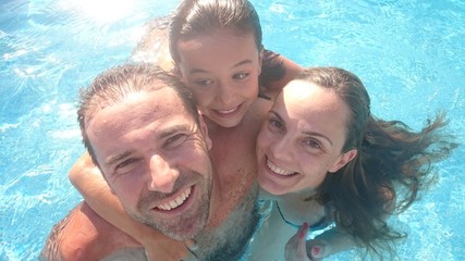 Familia sonriente en la piscina