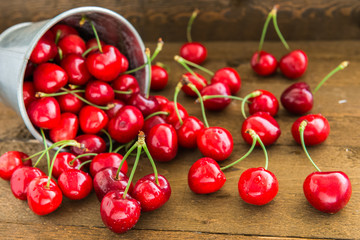 Cherries on wooden table with water drops.
