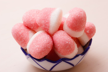 Pink jellies or marshmallows with sugar in bowl