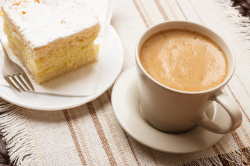 cup with coffee and cake on table