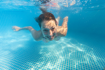 Underwater woman in swimming pool.