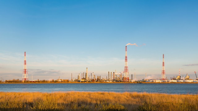 Timelapse sequence of a large oil refinery in the harbor of Antwerp, Belgium with blue sky and warm evening light.