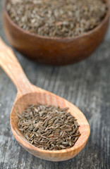 dried cumin on wooden surface