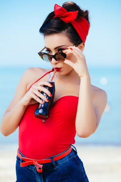 Pin-up at sea drink and watch over sunglasses