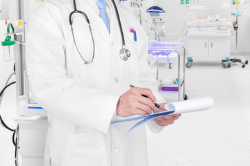 Fototapeta premium Doctor writing a medical prescription in delivery room