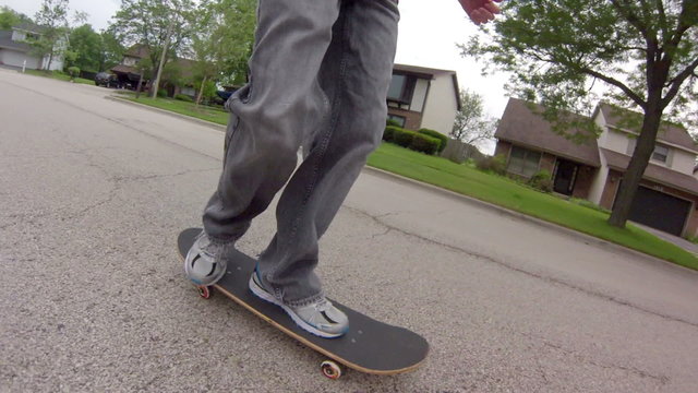 Skateboarding on Street – Low angle tracking shot, following a skater skateboarding down the street.