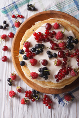 Crepes with berries and cream close-up. vertical top view