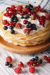Pile of crepes with berries close-up on a plate. Vertical
