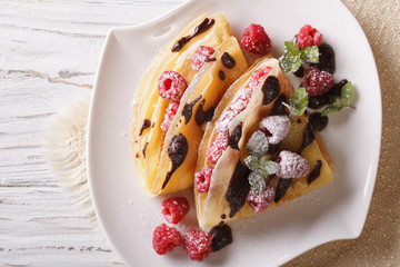 raspberry crepes with chocolate and mint closeup. horizontal top view
