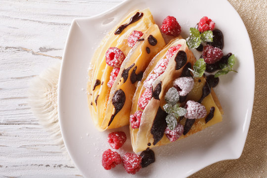 raspberry crepes with chocolate and mint closeup. horizontal top view
