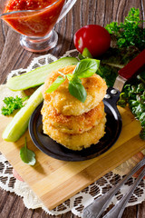 Vegetable burgers made from potatoes, corn and green peas on a wooden table