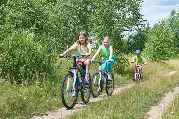 Happy kids on bike ride at country road