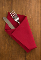 knife and fork at napkin on wood