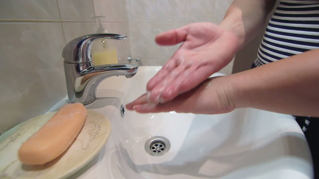 Woman applying hand moisturizer cream in the bathroom close-up