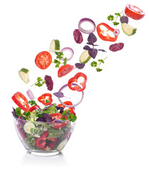 Vegetables for a salad of lettuce falling. Isolated on white.