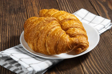 Two croissant on a plate.