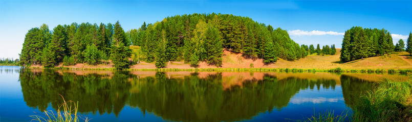 Panorama of village pond and forest reflection