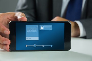 Composite image of businessman using smartphone